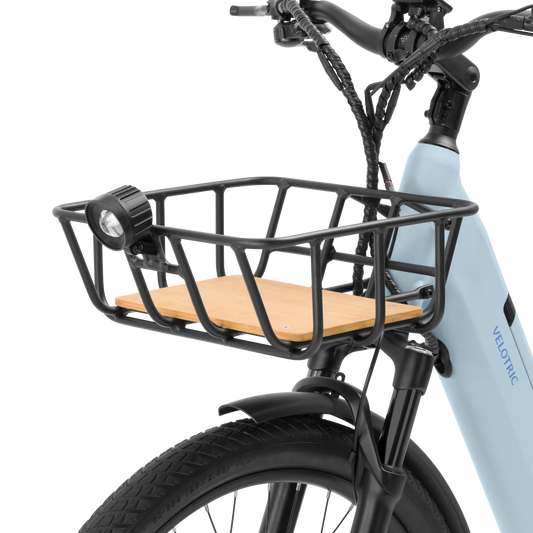 A black metal front bicycle basket mounted on a bike, shown from a side angle with a focus on the basket's sturdy frame and attachment points.