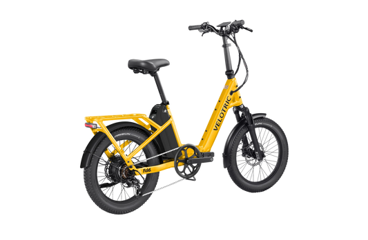 Velotric Fold 1 Plus electric bike in Mango color, folded for compact storage, shown against a plain background.